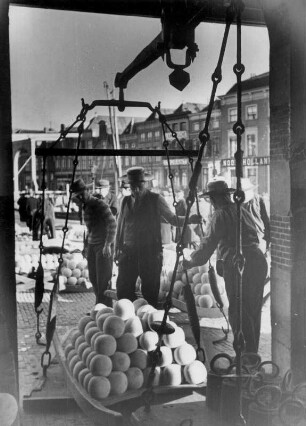 Niederlande. Käse Stadt Alkmaar. Mitglieder der Käseträger-Gilde wiegen auf der alten Stadtwaage die auf den Tragebrettern befindliche Käselast. Aufgenommen 1936