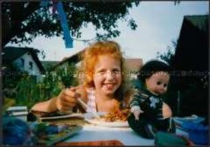 Rothaariges Mädchen isst Spaghetti (Altersgruppe bis 14)