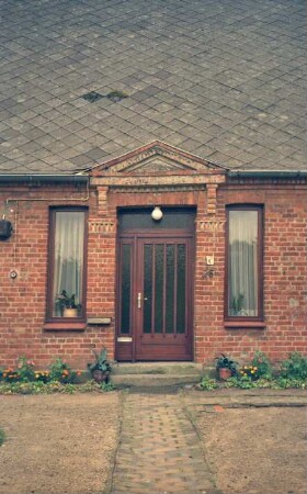 Stubbendorf: Alte Dorfstraße 26: Wohnhaus: Traufseite, Teilansicht: Eingangstür, darüber Dreiecksgiebel