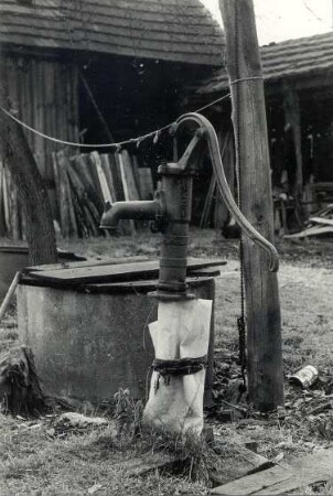 Schwengelpumpe in Heinersbrück : Nahrung - Wasserversorgung. Ort: Most / Heinersbrück. Kleine Schwengelpumpe neben einem abgedeckten Ziehbrunnen