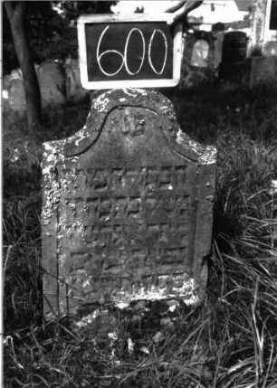 Grabstein 600 (Index: 100105046) Material: Sandstein Zustand: leicht verwittert, unten abgeblättert, teilweiser Textverlust Maße HxBxT: 64x45x7 cm Beschreibung: Stele, Konvexbogenabschluss, Schriftfeld eingetieft: Grabstein 600