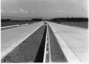 Trassierung mit Blick von der AS Riegel in Richtung Basel, Betonfahrbahndecke, Mittelstreifen humusiert, Doppelleitplake im Mittelstreifen.