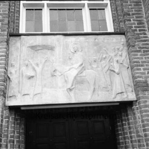 Evangelische Auferstehungskirche: Alte Landstraße: Relief "Jesus' Einzug in Jerusalem" des Bildhauers Siegfried Assmann über Eingang: darüber Fenster