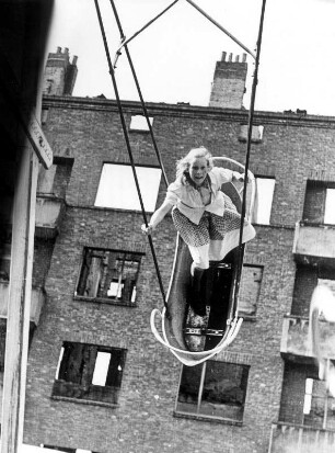 Hamburg 1949. Ein Mädchen schaukelt unbekümmert inmitten von Trümmern.