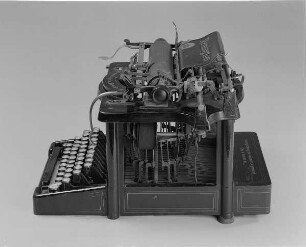 Typenhebelschreibmaschine "Remington" (Modell 7). Unteranschlag (nicht sofort sichtbare Schrift), Universaltastatur mit 42 Tasten, 23-mm-Farbband. Seitenansicht