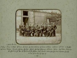 21 Offiziere in Uniform, mit Pickelhaube teils mit Orden des 2. Bataillons, stehend oder sitzend, vor Lagerschuppen