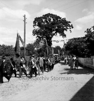 Volks- und Schützenfest: Schützenverein Sprenge und Umgebung e.V.: Festumzug der Schützenmannschaften: hinten Hecke, Mauer und Bäume