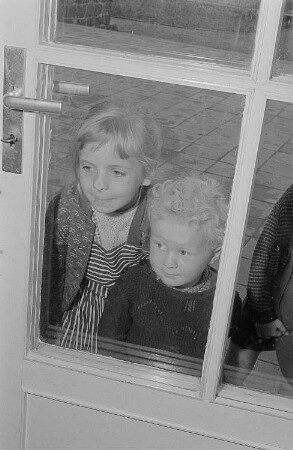 Kinder an einer Glastür einer Betreuungseinrichtung