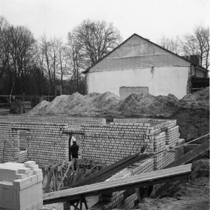 Tremsbüttel-Dorf: Gemeindezentrum: Mehrzweckhalle: Erweiterungsbau mit Bühne und Nebenräumen: Mitglieder der Freiwilligen Feuerwehr und des VfL Tremsbüttel von 1968 e.V. bei der Arbeit an Grundmauern: hinten rechts Gebäude