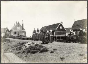 Niederlande, Marken. Deich mit Passanten und Wohnhäusern