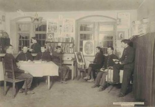 Acht Kriegsgefangene beim Lesen bzw. Porträtmalen in Künstlerwerkstatt im Kriegsgefangenenlager Hohenasperg