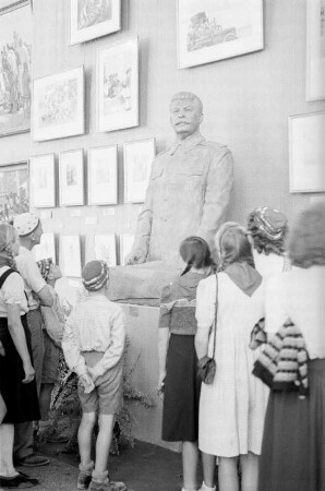 Ausstellung der Sowjetunion im Gebäude des Finanzministeriums der DDR am Werderschen Markt anlässlich der III. Weltfestspiele in Berlin : Ausstellungsbesucher vor einer Plastik von Josef Stalin