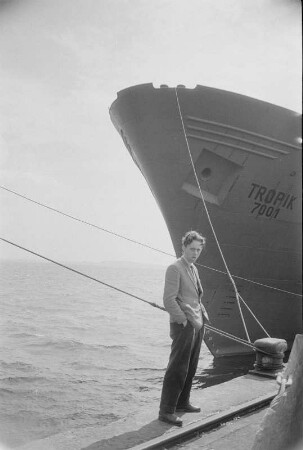 Stralsund. VEB Volkswerft Stralsund. Gewerk 114, Brigade Heidenreich. Fang- und Gefrierschiff "Tropik 7001" am Ausrüstungskai. Blick auf vertäuten Bug und Brigademitglied am Kai
