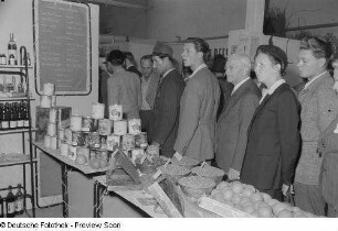 Besucher an einem Stand mit agrarischen Erzeugnissen, Herbstmesse 1953