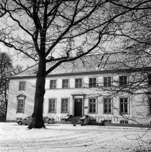 Gut Altfresenburg: das Herrenhaus im Winter: Ansicht der Vorderfront, links ein parkender Pkw