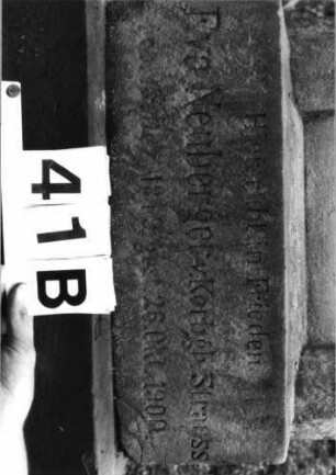 Grabstein 41 (Index: 100079889) Material: Sandstein Zustand: beschädigt und verwittert mit Textverlust, Schrift schwarz ausgemalt Maße HxBxT: 165x55x38 cm Beschreibung: ädikulaartige Stele mit Halbsäulen, getreppter Sockel, eingezogener Rundbogenabschluß mit Aufsatz Symbolik: gestelztes Rundbogenfries: Grabstein 41B