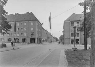 Unbekannter Ort. Blick auf eine Straßenkreuzung mit Wohn- und Geschäftshäusern (HO-Laden, Sibylle-Friseurhandwerk)