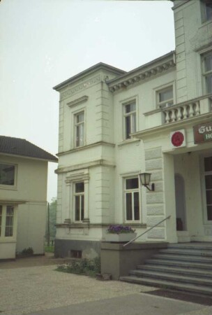 Gut Wulksfelde: ehemaliges Herrenhaus: Eingangsfront: Teilansicht: Mittelrisalit mit Treppe, Eingangsvorbau und Altan, daran Schild "Gutsklause": Eckrisalit: links Seitenflügel