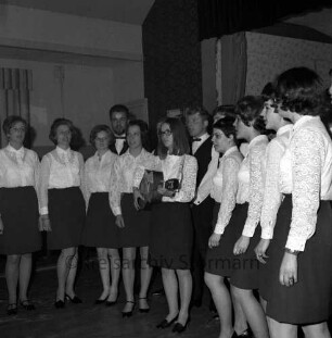 Landjugend Bargteheide: Feier zum 22-jähriges Jubiläum: Festsaal: Chor der Landjugend Bargteheide singt: Bildmitte Gitarrenspielerin: Mädchen in dunklen Röcken und weißen Spitzenblusen: rechts im Hintergrund Bühne, 8. März 1969