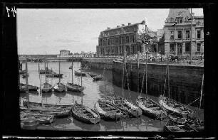 [Ostende (?) (Belgien)]: zerstörte repräsentative Gebäude am Kai, im Vordergrund mehrere kleine Segelboote vor der Kaimauer