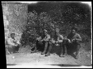 Lille (Dep. Nord, Frankreich): 4 Gefangene unterhalb einer Böschung nebeneiner Backsteinmauer kauernd ("Einbringen von Gefangenen auf der Zitadelle Lille")