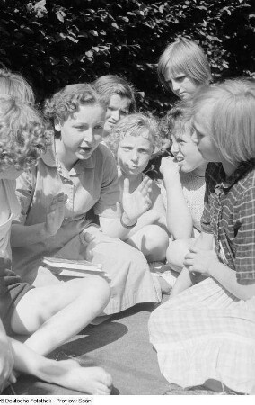 Büchereiangestellte Krüger der Stadtbücherei Mitte liest Kindern aus einem Buch vor