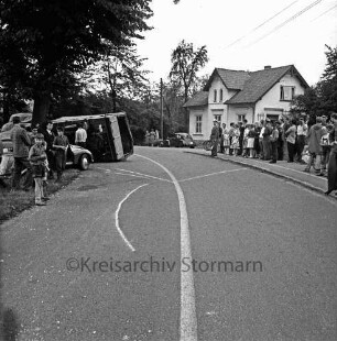 Verkehrsunfall: B 75: Kurve vor Schloss: Cabriolet und Lkw: eschädigtes Cabriolet, umgestürzter Lastwagen, Schaulustige, Verkehrspolizist: : Kreide-Markierungen auf Straße: hinten rechts Wohnhaus