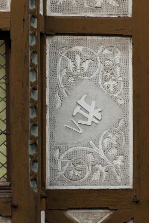 Gefachfeld mit Ornamentik und Schild mit Handwerksemblem