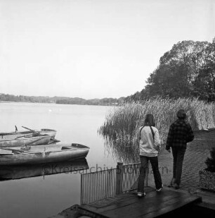 Lütjensee: Bootsteg des Hotels und Restaurants "Fischerklause": vorn zwei Jugendliche auf Steg: links Ruderboote