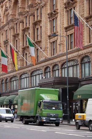 Fassade Luxus-Kaufhaus Harrods, davor grüner Harrods Lieferwagen