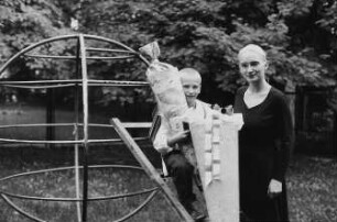 Mutter mit ihrem Sohn am Einschulungstag auf einem Spielplatz