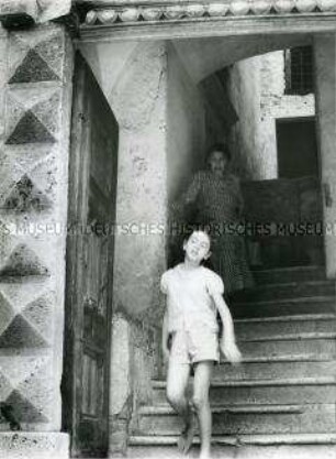 Junges Mädchen und alte Frau steigen eine alte Treppe hinunter