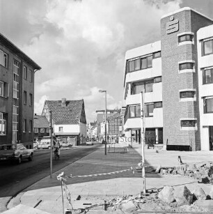 Kreissparkasse Stormarn: Hagenstraße: Zentrale: in Bau: Innenausbau und Herrichtung des Vorplatzes: Blick von Einmündung Weg zum Bürgerpark: im Vordergrund Pflastersteine, Absperrband, links Eckhaus zum Markt Altbau Kreissparkasse: Verkehrsschilder, Straßenlampen: Autos, Handwerker auf Fahrrad