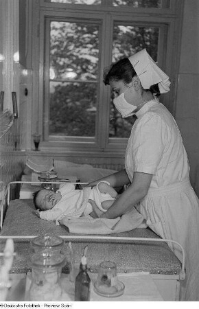 Krankenschwester mit Neugeborenem auf der Säuglingsstation