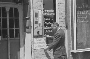 Währungsreform in den westlichen Sektoren im Juni 1948. Ladeninhaber befestigt ein Hinweisschild "Wegen Währungsrefom geschlossen" am Eingang zu seiner Drogerie