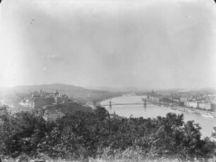 Stadtansicht : Blick vom Gellértberg donauaufwärts über Budapest. Links ist die Königliche Burg (Királyi Vár) und die Kettenbrücke zu sehen; rechts im Bild die Pest mit Kuppel des ungarischen Parlaments. Im Hintergrund befinden sich Margaretenbrücke und Margareteninsel.