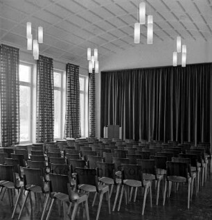 Haus Lichtensee: Propstei Stormarn: evangelisches Zentrum mit Altersheim und Jugendheim: Erweiterungsbau vor Einweihung: Blick in den Saal über Stuhlreihen auf die Bühne mit Vorhang