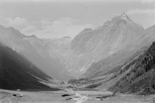 Siedlung : Siedlung im Tal am Fuße eines Bergmassivs.