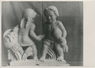 Nasenschild Bäckerei H. Schriefer: Knabe und Mädchen bei Händedruck, mit Korb, Brot, Getreidegarben: Entstehungsprozess: Tonmodell in Atelier, hinten Vorhang