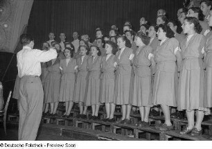 Gemischter Chor und Chorleiter auf der Bühne bei einer Kulturveranstaltung der Gewerkschaft Handel