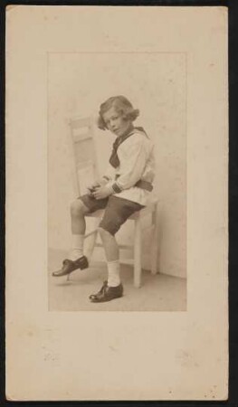 Raimund von Hofmannsthal als Junge auf einem weißen Stuhl sitzend