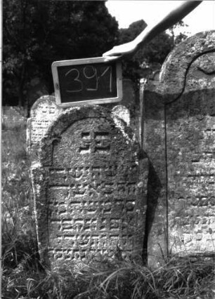 Grabstein 391 (Index: 100102839) Material: Sandstein Zustand: leicht verwittert Maße HxBxT: 80x45x10 cm Beschreibung: Stele, eingezogener Rundbogenabschluss, Schriftfeld eingetieft: Grabstein 391