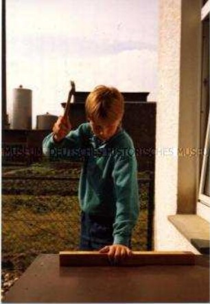 Junge mit erhobenem Hammer (Altersgruppe bis 14)