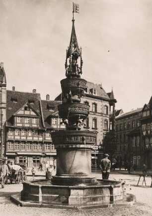 Braunschweig. Ansicht des, 1408 in spätgotischer Bauweise errichteten, Altstadtmarktbrunnen. Im Hintergrund historische Wohnbebauung im Fachwerkstil