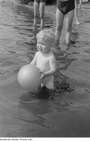 Kleiner Junge, mit einem Ball im Wasser spielend