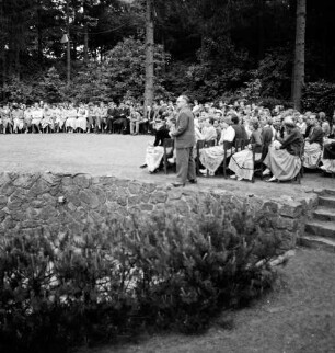 Tag der Deutschen Einheit: Feierstunde: Naturbühne: Bürgerpark: Bühne: Landesminister für Kultur Edo Osterloh hält Rede: Schülerinnen und Schüler auf Stühlen im Halbrund, 17. Juni 1956