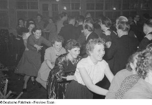 Gäste einer Betriebsweihnachtsfeier beim Tanzen einer Polonaise