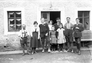 Gruppenbildnis, aufgenommen vor einem Wohnhaus mit Laden (?) (Inhaber Hermann Klotz)