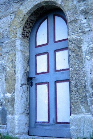 Rundbogenportal an der Nordseite des Langhauses mit lateinischer Inschrift "MCCCXVII…"