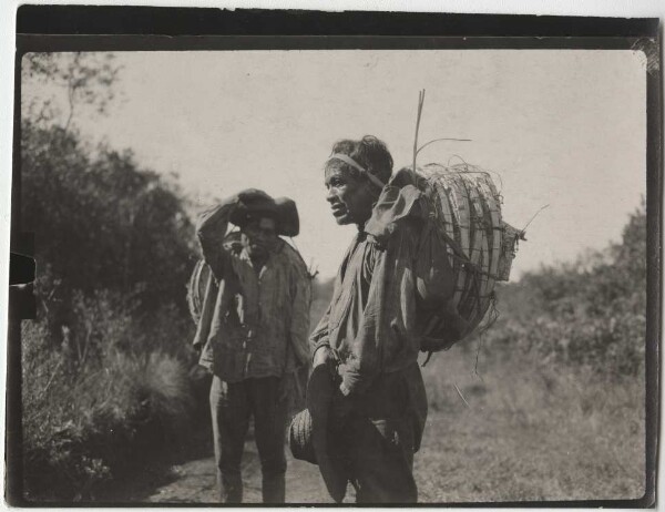 Two Kaingang carrying baskets